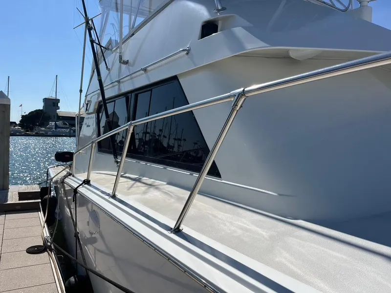 Slide: The Image of 1988 Hatteras 52 Convertible yacht docked, showcasing sleek design and polished railing. - 3