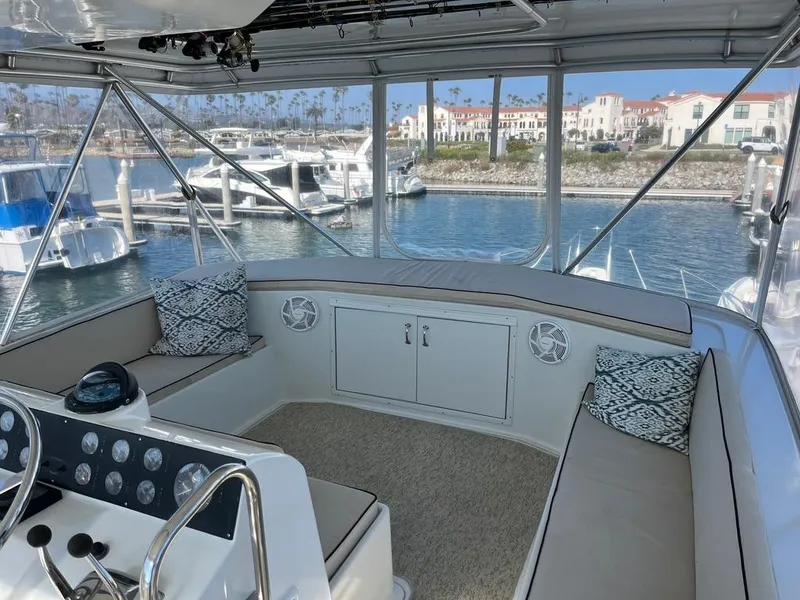 Slide: The Image of 1988 Hatteras 52 Convertible yacht interior with seating, helm, and marina view. - 31