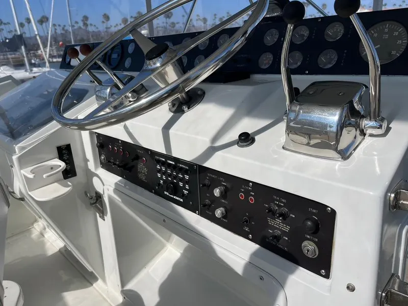 Slide: The Image of Control panel of a 1988 Hatteras 52 Convertible yacht with steering wheel and gauges. - 34