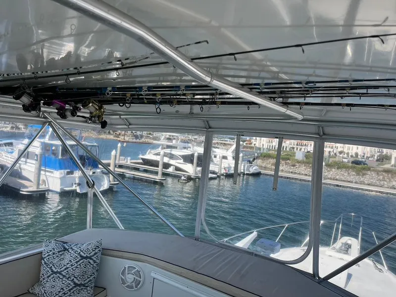 Slide: The Image of Interior view of 1988 Hatteras 52 Convertible yacht with fishing rods and marina backdrop. - 37