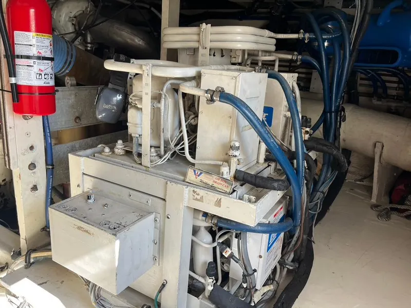 Slide: The Image of Engine room of 1988 Hatteras 52 Convertible with machinery and fire extinguisher. - 46