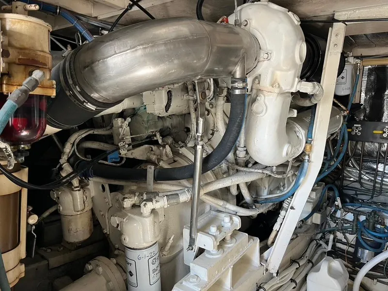 Slide: The Image of Engine room of 1988 Hatteras 52 Convertible yacht, showcasing complex machinery and piping. - 47