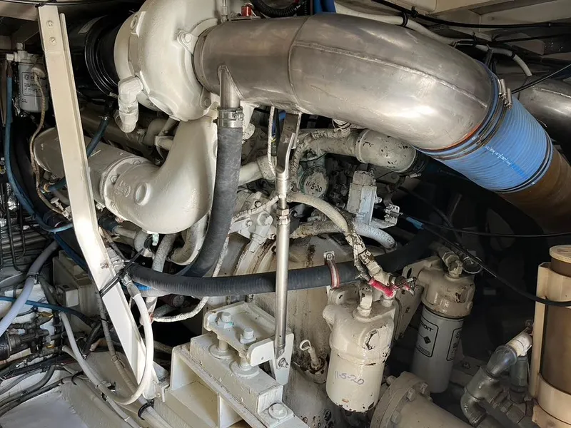 Slide: The Image of Engine room of a 1988 Hatteras 52 Convertible yacht, showcasing complex machinery and piping. - 48