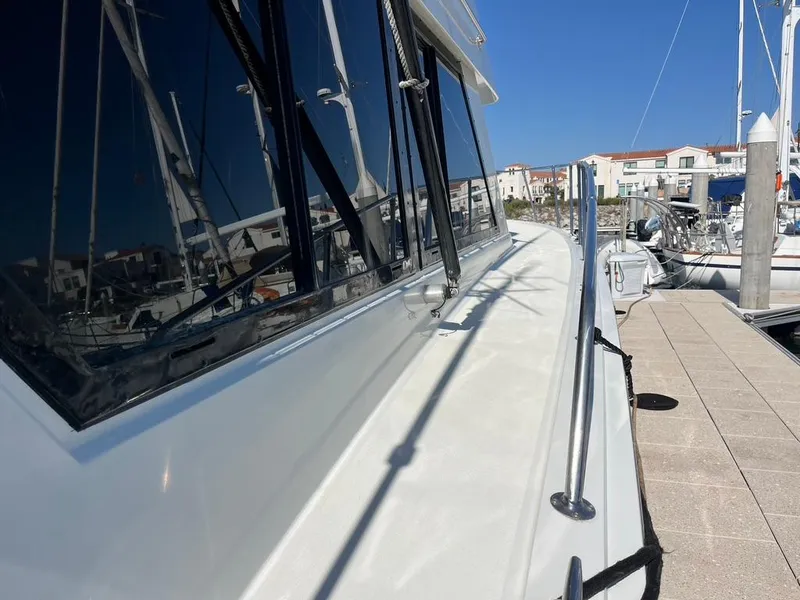 Slide: The Image of 1988 Hatteras 52 Convertible yacht docked at marina, showcasing sleek design and reflective windows. - 5