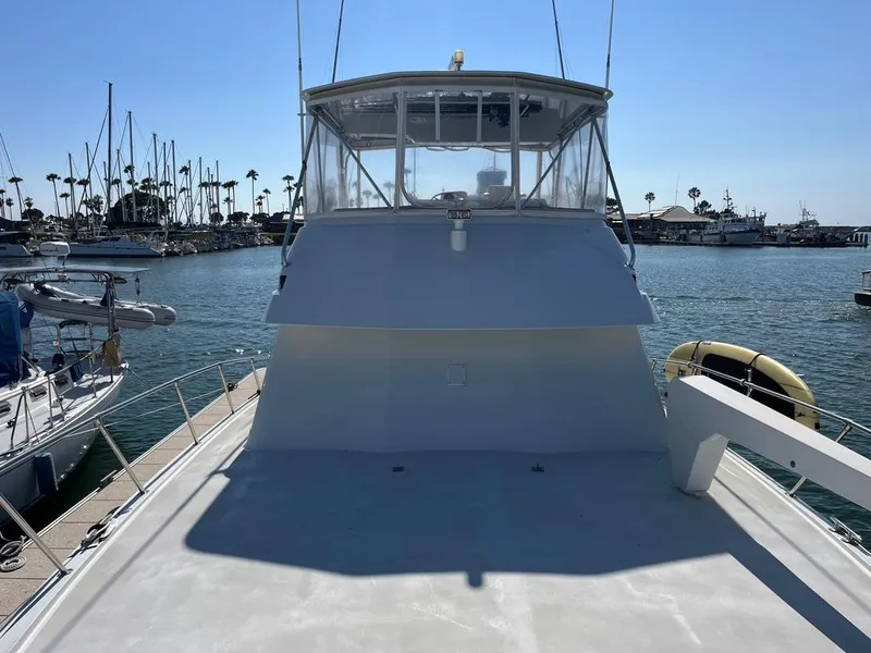 Slide: The Image of 1988 Hatteras 52 Convertible yacht docked in a marina under clear blue skies. - 9