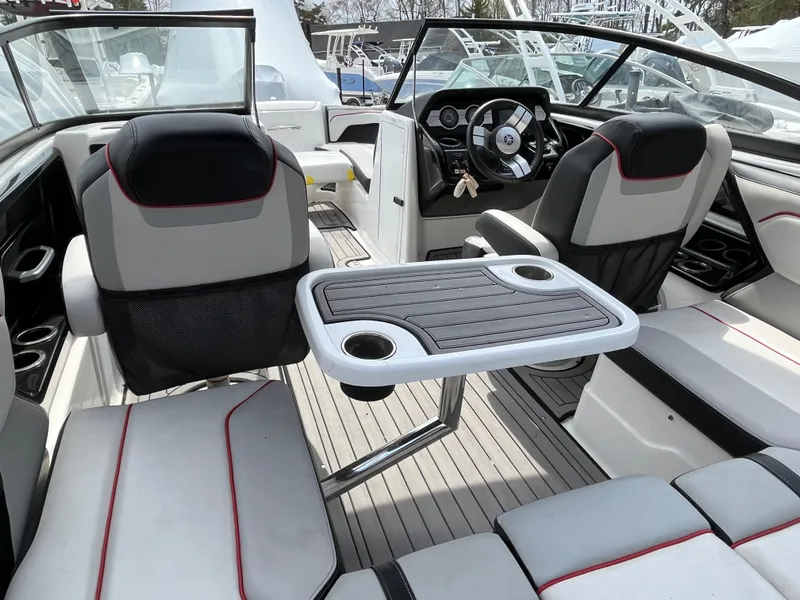 Slide: The Image of 2018 Yamaha Boats 212X interior with seating and table, featuring modern design and steering console. - 10