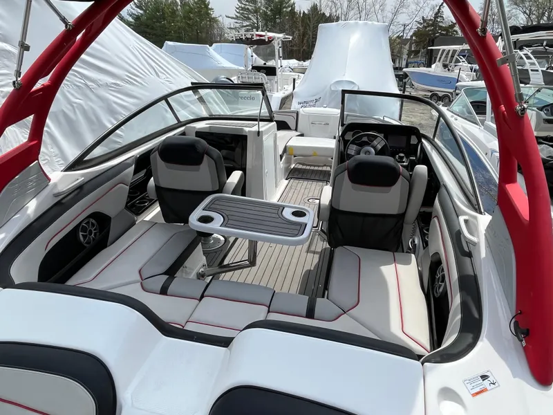 Slide: The Image of 2018 Yamaha Boats 212X interior with seating and table, featuring red accents and modern design. - 11