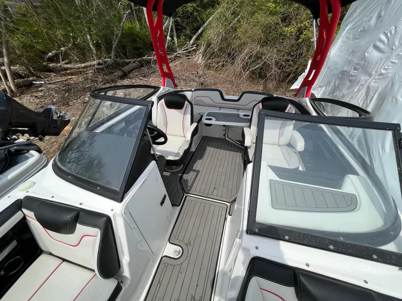 Slide: The Image of 2018 Yamaha Boats 212X interior with seating and steering, featuring red accents and open canopy. - 14