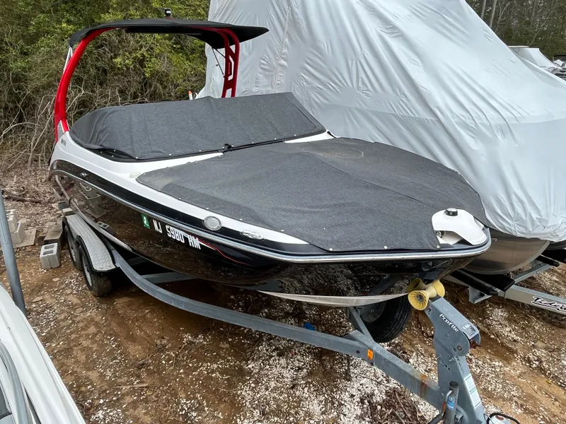 Slide: The Image of 2018 Yamaha Boats 212X covered on trailer, parked outdoors. - 16