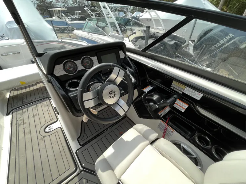 Slide: The Image of 2018 Yamaha Boats 212X cockpit with steering wheel, dashboard, and seating. - 17