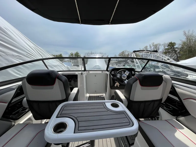 Slide: The Image of 2018 Yamaha Boats 212X interior with seating and table, under a canopy. - 22