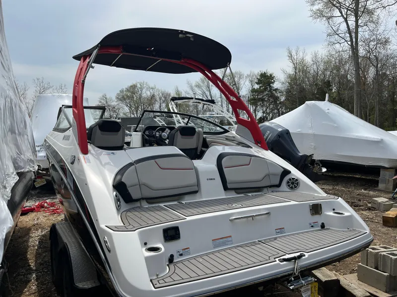 Slide: The Image of 2018 Yamaha Boats 212X with red accents, parked outdoors on a trailer. - 9