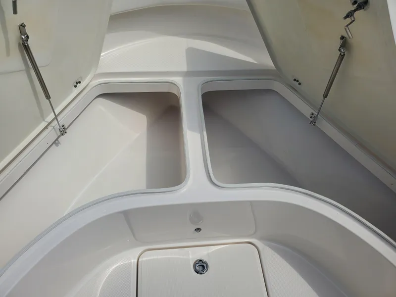 Slide: The Image of 2022 Robalo R222 Center Console storage compartments open, showcasing spacious interior design. - 14