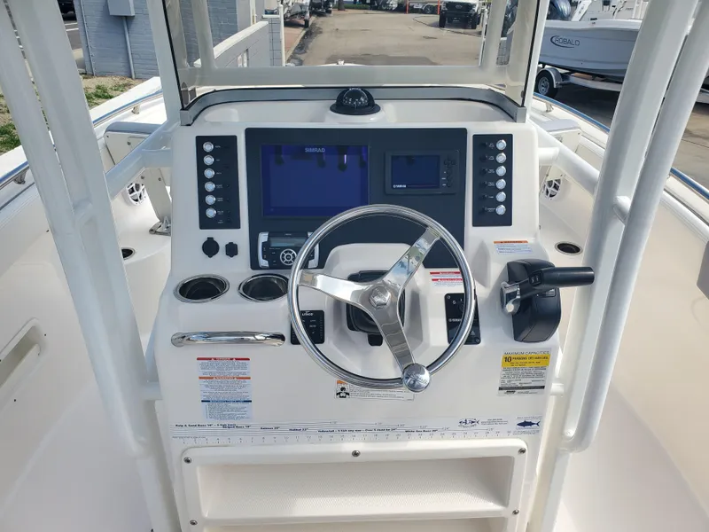 Slide: The Image of 2022 Robalo R222 Center Console boat dashboard with steering wheel and electronic controls. - 16