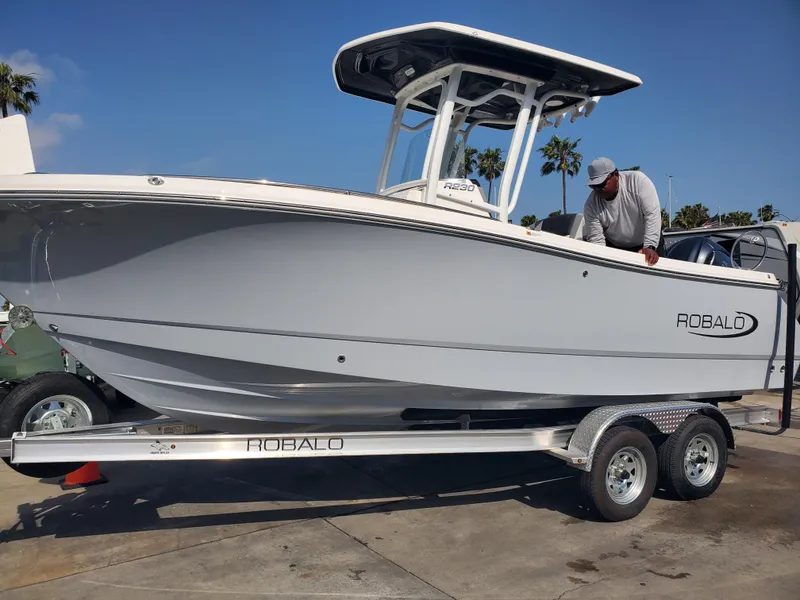 Slide: The Image of 2022 Robalo R222 Center Console boat on trailer, parked outdoors. - 22