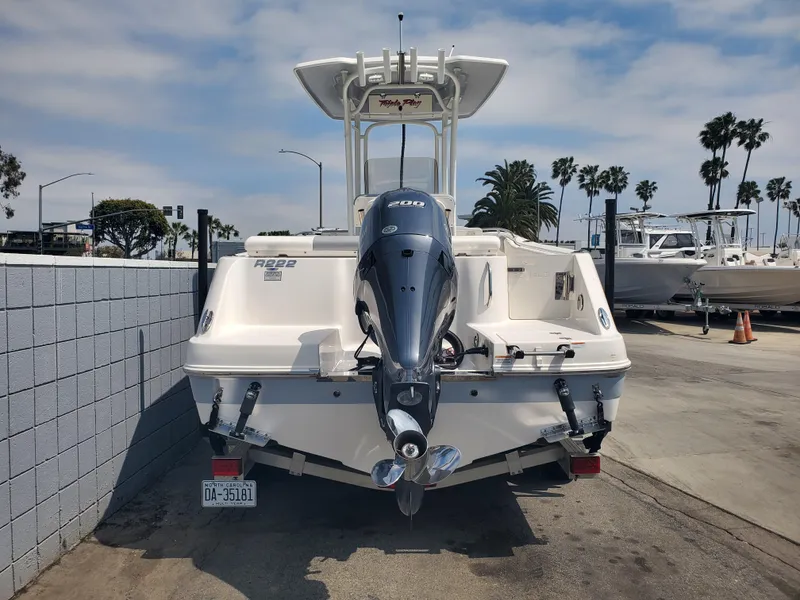 Slide: The Image of 2022 Robalo R222 Center Console boat with outboard motor, parked on a sunny day. - 4