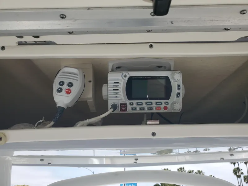 Slide: The Image of 2022 Robalo R222 Center Console boat radio and microphone in storage compartment. - 8