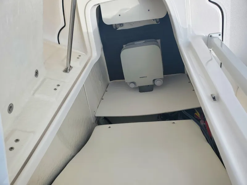 Slide: The Image of 2022 Robalo R222 Center Console interior storage compartment with white finish and equipment. - 9