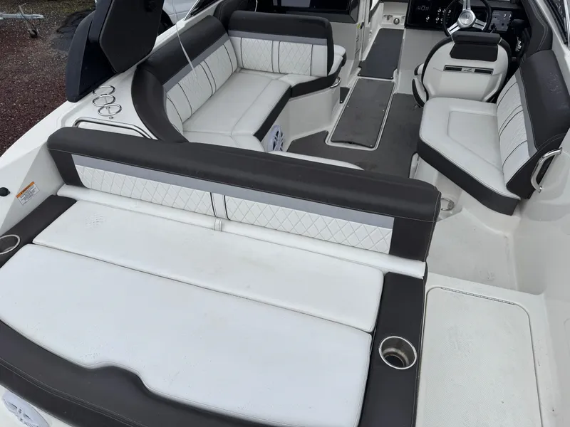Slide: The Image of 2017 Sea Ray SLX 230 boat interior with white and black seating, cup holders, and sleek design. - 2