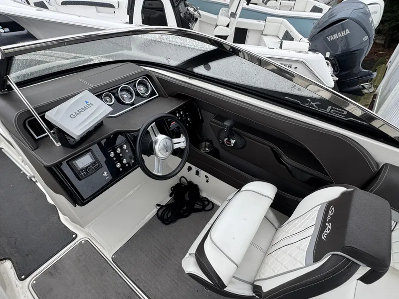 Slide: The Image of 2017 Sea Ray SLX 230 boat cockpit with steering wheel and Garmin navigation system. - 8