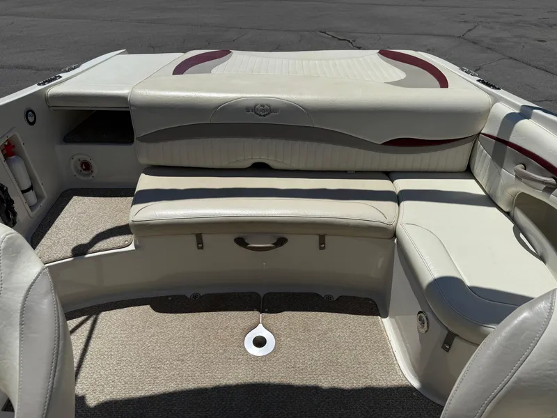 Slide: The Image of 2013 Stingray 235 CR boat interior with beige seating and carpeted flooring. - 19