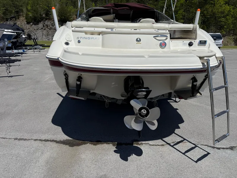 Slide: The Image of 2013 Stingray 235 CR boat rear view with propeller and ladder on a sunny day. - 2