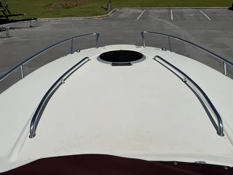 Slide: The Image of 2013 Stingray 235 CR boat deck with hatch and railings in a parking area. - 9