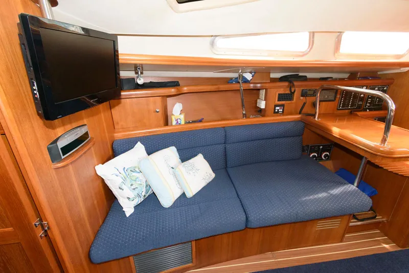 Slide: The Image of Interior of 2004 Hunter 44 Deck Salon with blue sofa and mounted TV. - 15