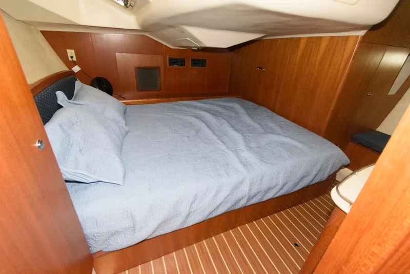 Slide: The Image of 2004 Hunter 44 Deck Salon cabin with a cozy bed and wooden interior. - 19