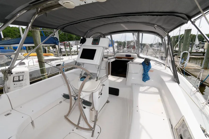 Slide: The Image of 2004 Hunter 44 Deck Salon sailboat cockpit with navigation equipment and canopy. - 4