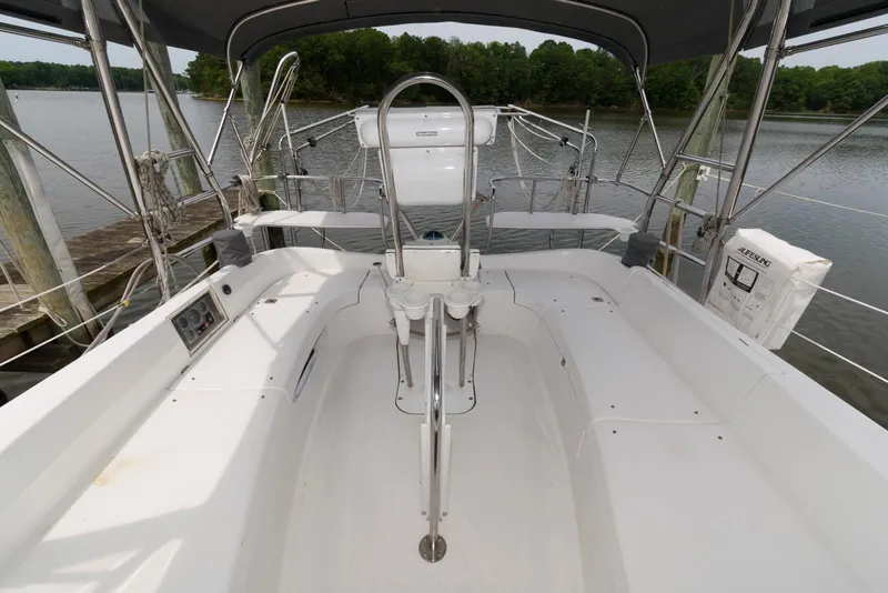 Slide: The Image of 2004 Hunter 44 Deck Salon yacht cockpit with seating, steering wheel, and water view. - 6