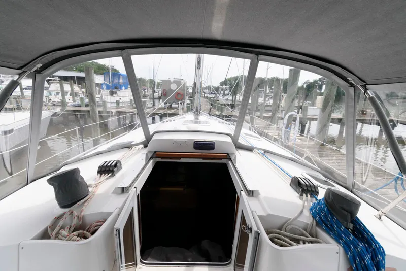 Slide: The Image of 2004 Hunter 44 Deck Salon sailboat cockpit view at marina, showcasing spacious design. - 7