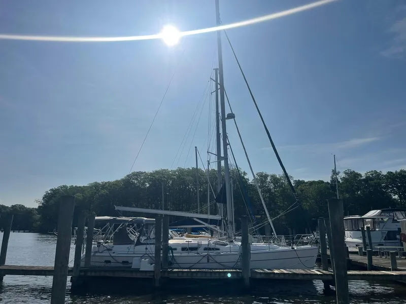 Slide: The Image of 2004 Hunter 44 Deck Salon sailboat docked under bright sun. - 9