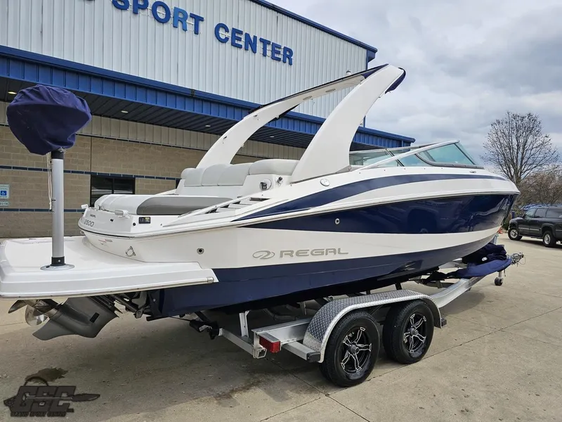 Slide: The Image of 2011 Regal 2500 Bowrider boat on trailer outside a sports center. - 10