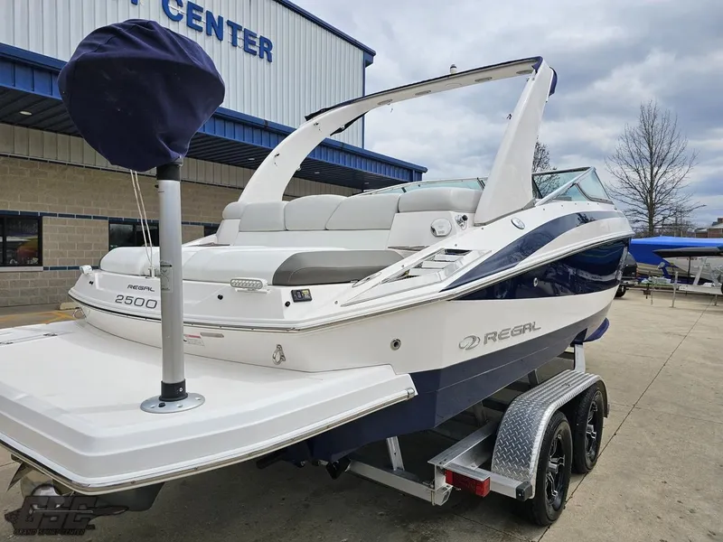 Slide: The Image of 2011 Regal 2500 Bowrider boat on trailer, parked outside a building. - 11