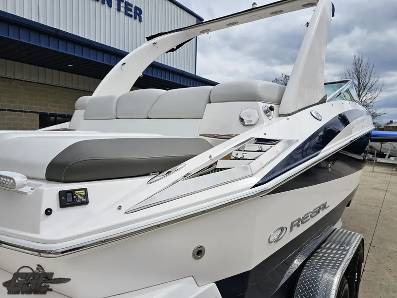 Slide: The Image of 2011 Regal 2500 Bowrider boat with sleek design, parked outdoors near a building. - 12