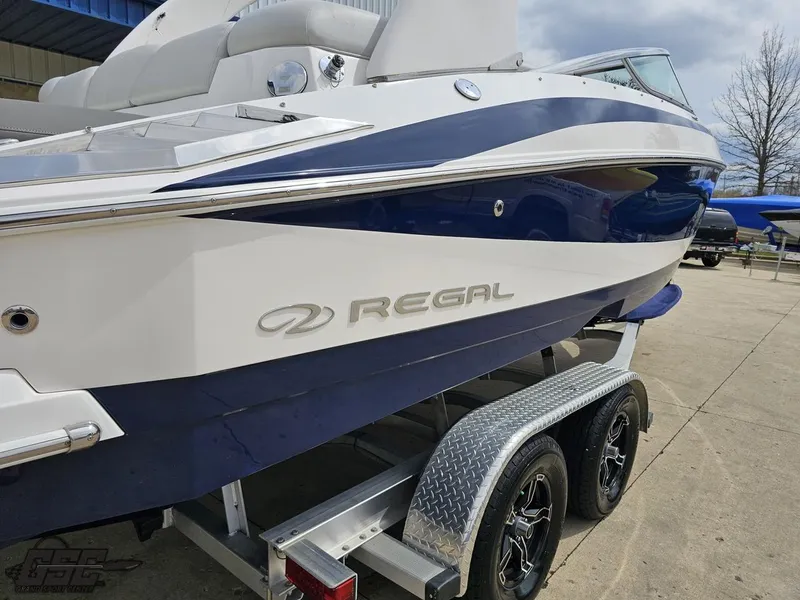 Slide: The Image of 2011 Regal 2500 Bowrider boat on trailer, blue and white design, side view. - 13