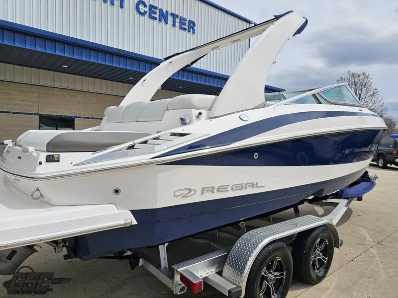 Slide: The Image of 2011 Regal 2500 Bowrider boat on trailer outside a marine center. - 14