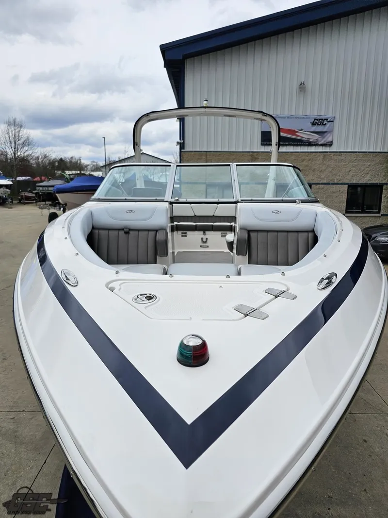 Slide: The Image of 2011 Regal 2500 Bowrider boat with sleek design, docked outdoors near a building. - 19