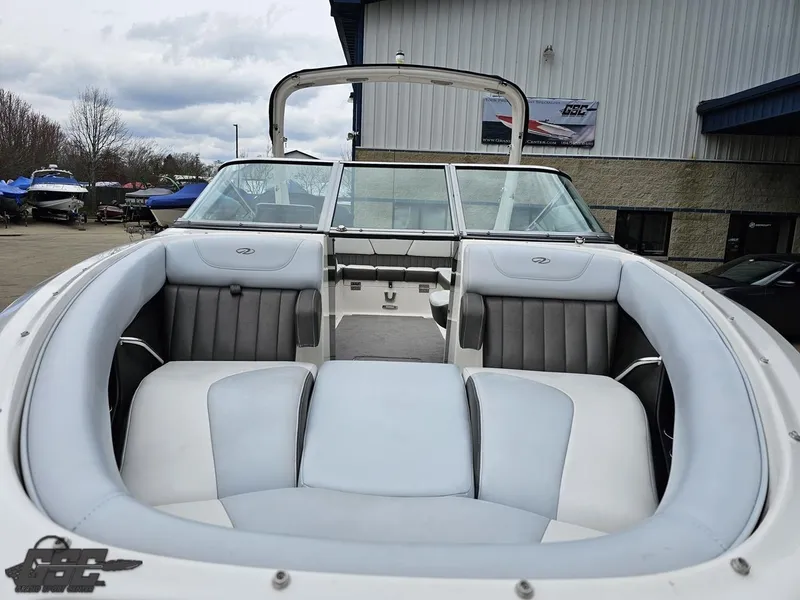 Slide: The Image of 2011 Regal 2500 Bowrider boat with spacious seating, docked near a building. - 20