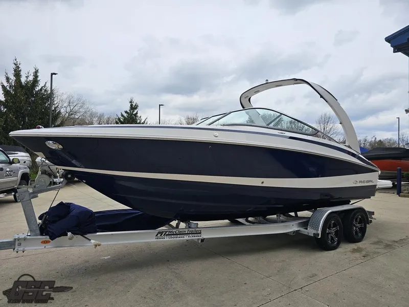 Slide: The Image of 2011 Regal 2500 Bowrider boat on trailer, parked outdoors, overcast sky. - 22