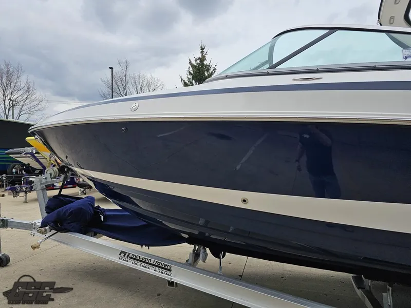 Slide: The Image of 2011 Regal 2500 Bowrider boat on trailer, blue and white exterior, parked outdoors. - 25