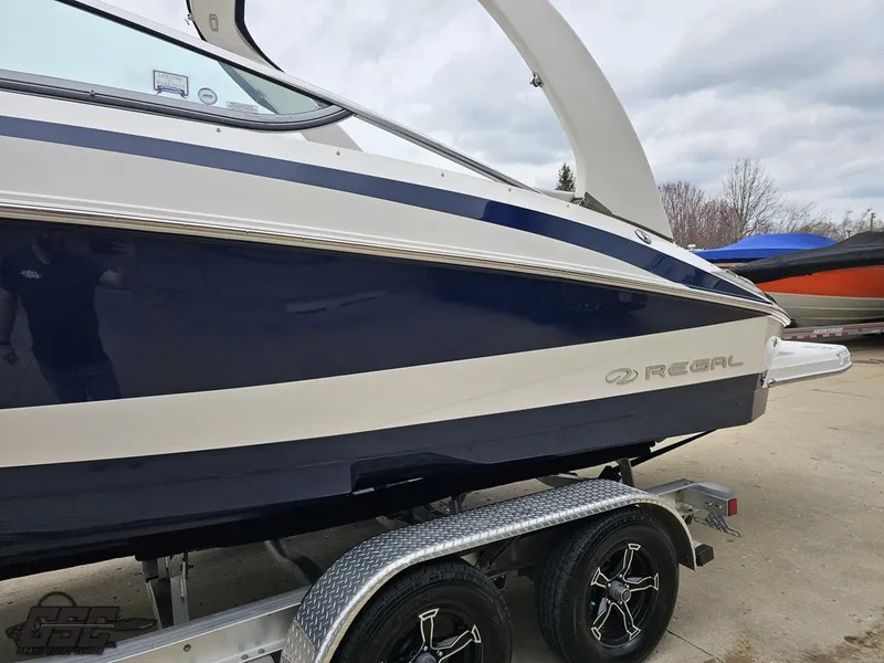 Slide: The Image of 2011 Regal 2500 Bowrider boat on trailer, side view, blue and white design. - 26