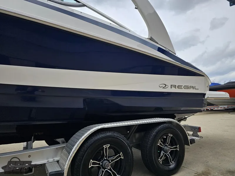 Slide: The Image of 2011 Regal 2500 Bowrider boat on trailer, featuring sleek design and dual wheels. - 27
