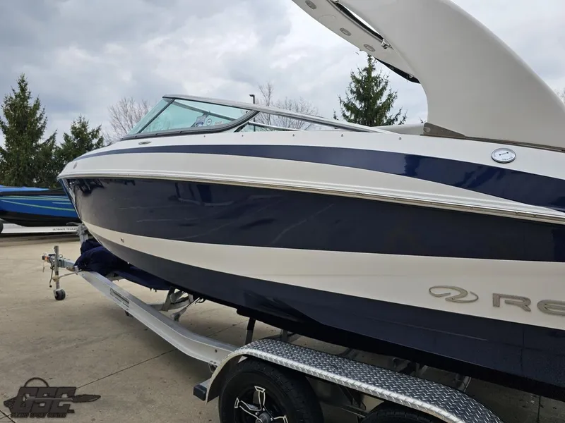 Slide: The Image of 2011 Regal 2500 Bowrider boat on trailer, blue and white design, parked outdoors. - 29
