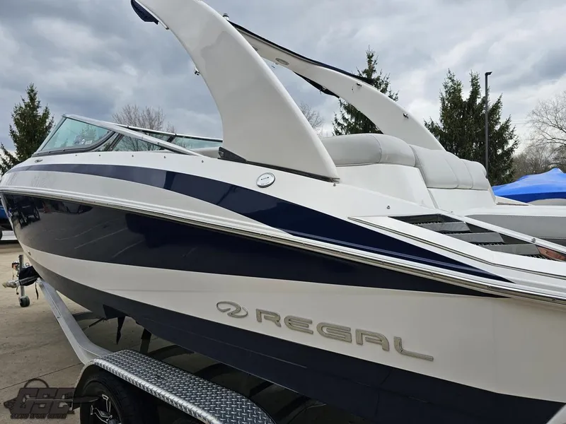 Slide: The Image of 2011 Regal 2500 Bowrider boat on trailer, sleek design, white and navy blue exterior. - 30