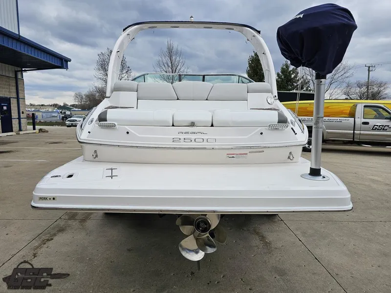 Slide: The Image of 2011 Regal 2500 Bowrider boat, rear view, parked on concrete, overcast sky. - 36