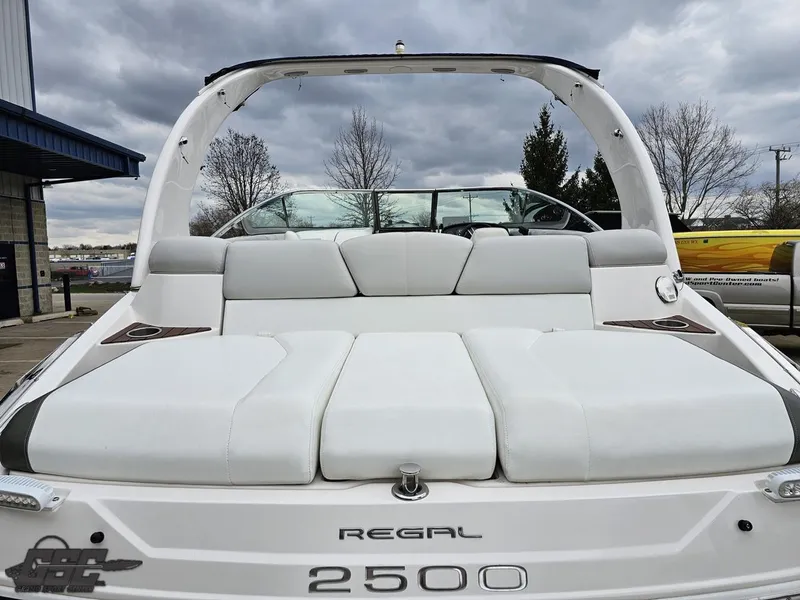 Slide: The Image of 2011 Regal 2500 Bowrider boat with white seating, docked under cloudy skies. - 39