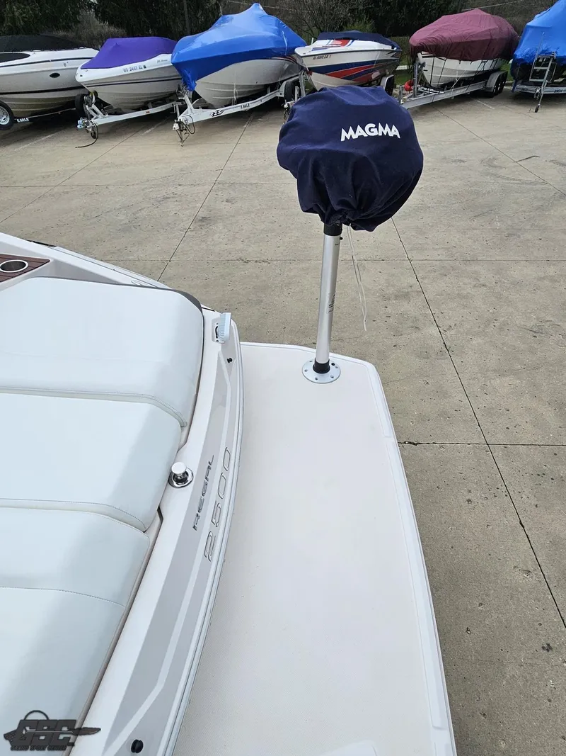 Slide: The Image of 2011 Regal 2500 Bowrider boat with Magma grill cover, docked with other covered boats. - 40