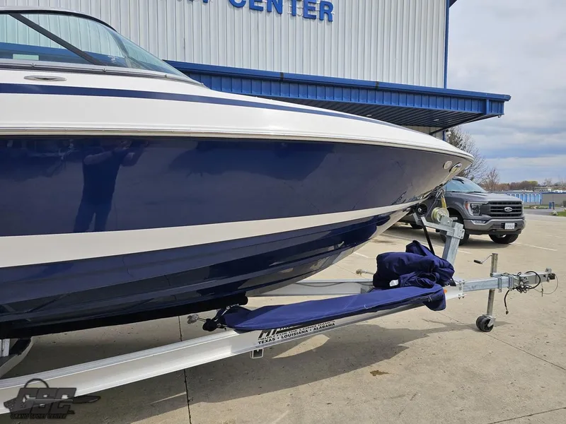 Slide: The Image of 2011 Regal 2500 Bowrider boat on trailer, parked outside a marine center. - 5